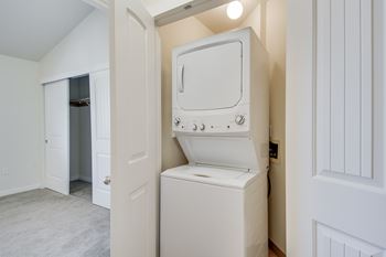 A white washing machine is in a small room.